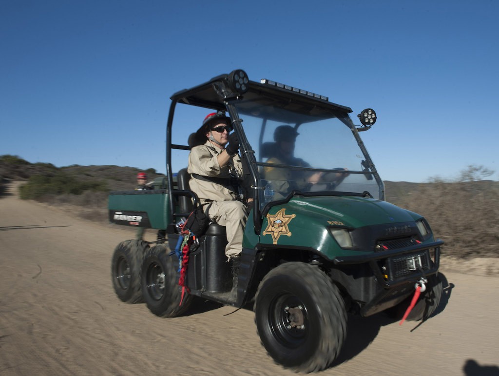 Members of the Orange County Sheriff's Search and Rescue Team ride a fire trail down in a Polaris off-road vehicle as they demonstrate the process of finding a lost subject in the Aliso Woods Wilderness Park.  The Polaris allow for a fast search over steep terrain in a search.