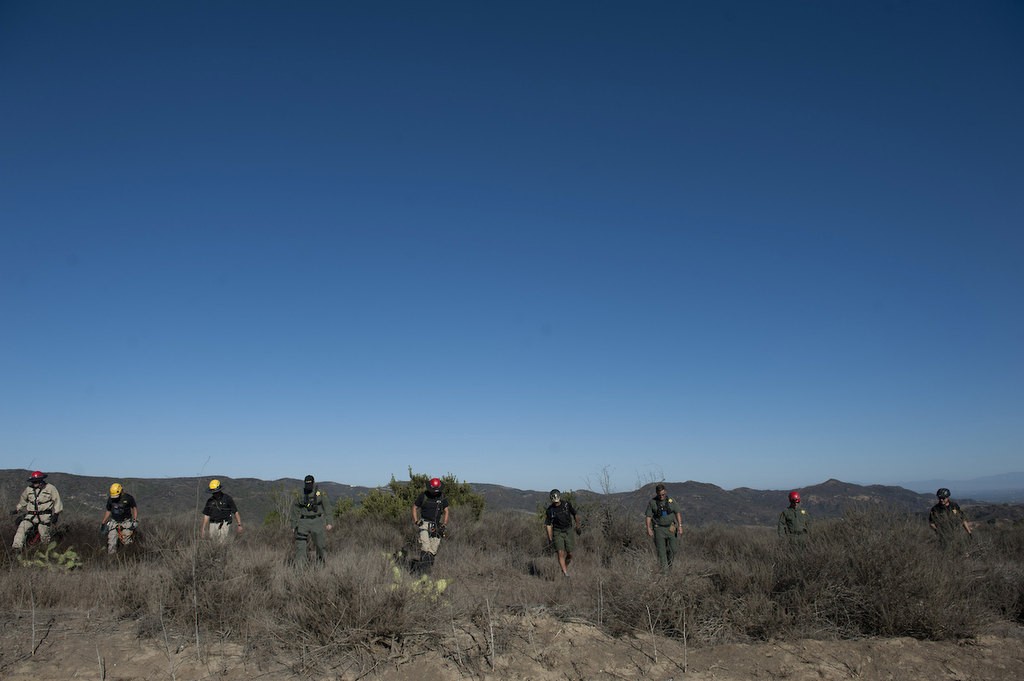 Members of the Orange County Sheriff's Search and Rescue Team demonstrate a line search in the process of finding a lost subject in the Aliso Woods Wilderness Park.