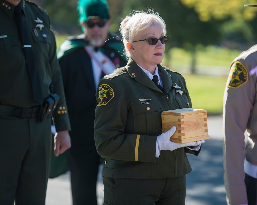 Chief senior chaplain for the Orange County Sheriff's Department Kathleen Kooiman carries the remains of baby Kathleen, an unidentified infant who was given a name, memorial and burial through the Garden of Innocence program Saturday at the El Toro Memorial Park Cemetery.