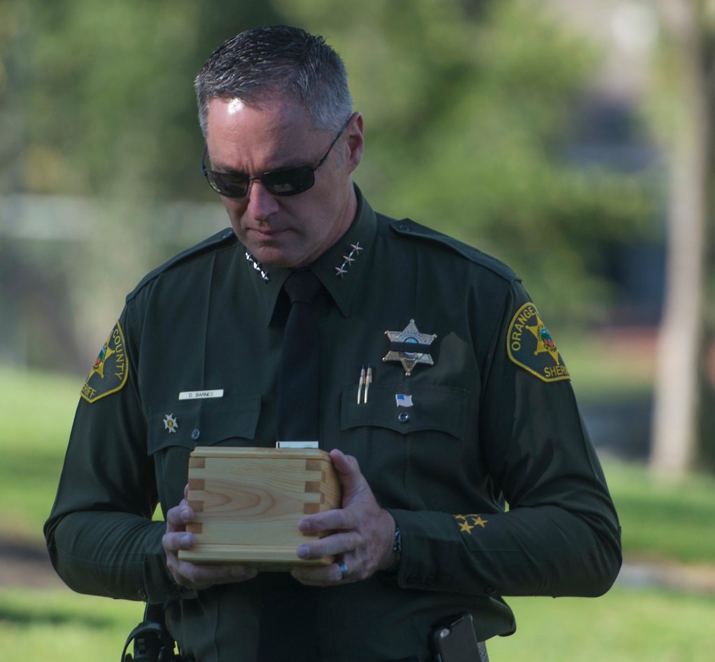 Orange County Undersheriff Don Barnes holds the remains of  baby Kathleen, an unidentified infant, as a symbolic gesture of holding a baby who likely was never held before her death. Kathleen was given a name, memorial and burial through the Garden of Innocence program Saturday at the El Toro Memorial Park Cemetery.