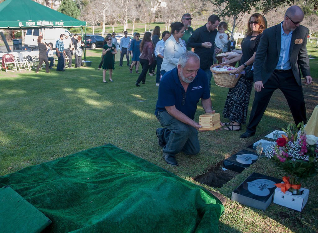 El Toro Memorial Park Cemetery Manager Bud Bales places the urn containing the remains of baby Kathleen in her grave during the memorial service for the unidentified infant.  The Orange County Garden of Innocence project provided her with a name and a burial site. Photo by Miguel Vasconcellos