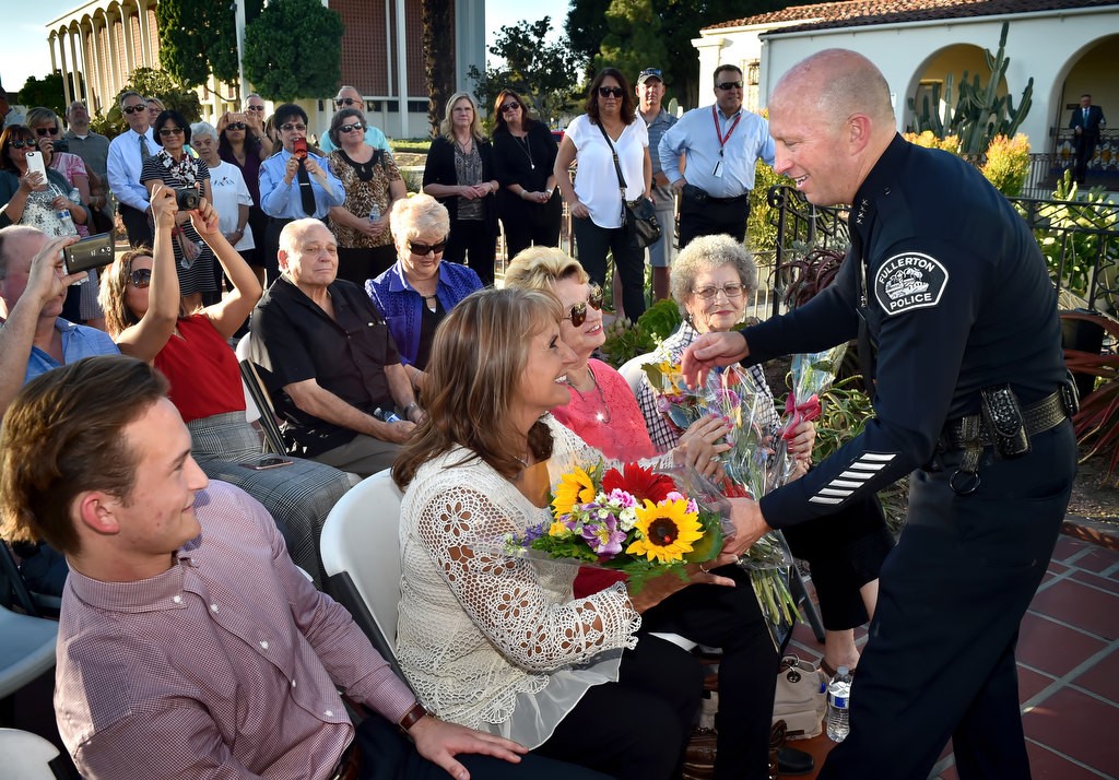 Retiring Fullerton Police Chief Dan Hughes brings flowers to his wife Kimberly Hughes, mother Marjorie Hughes and grandmother Nancy Randolph during his retirement ceremony. Chief Hughes’ son Grant Hughes is left. Photo by Steven Georges/Behind the Badge OC