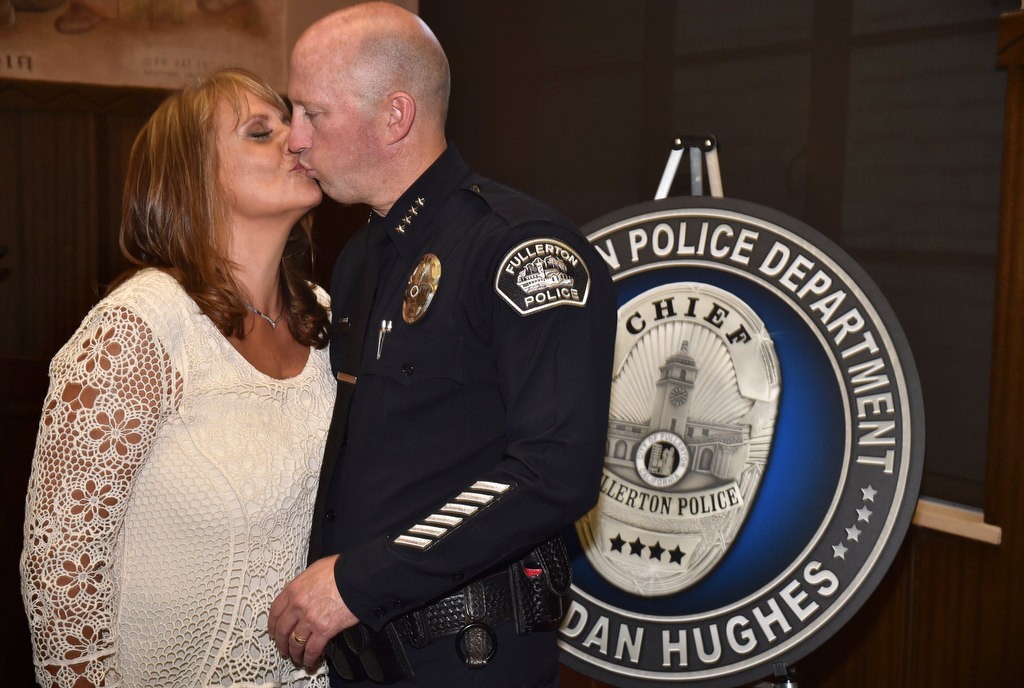 Kimberly Hughes gives a kiss to her husband Police Chief Dan Hughes at the conclusion of his retirement ceremony. Photo by Steven Georges/Behind the Badge OC