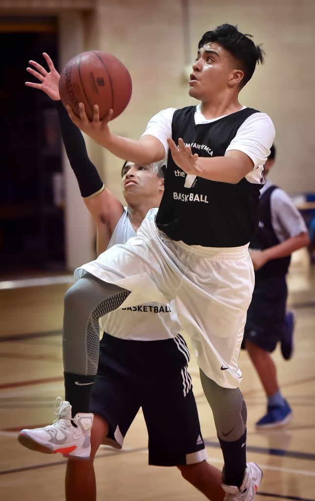 Ivan Delgado scores at the basket during a game at the West Anaheim Youth Center. Photo by Steven Georges/Behind the Badge OC