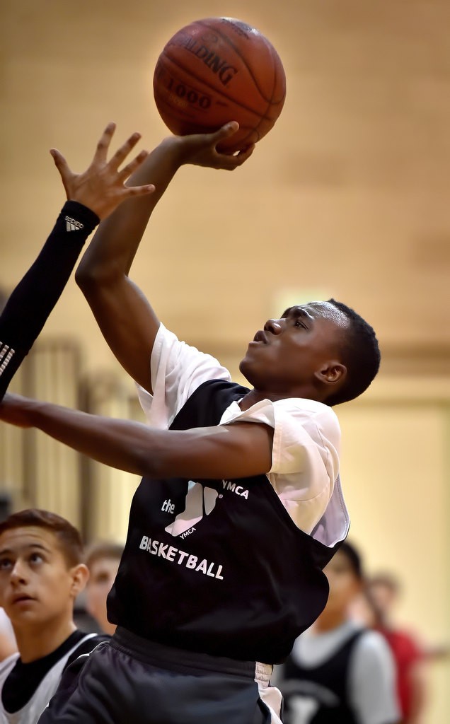 Ekenedilichukwu Aladiume shoots and scores at the basket during a game at the West Anaheim Youth Center. Photo by Steven Georges/Behind the Badge OC