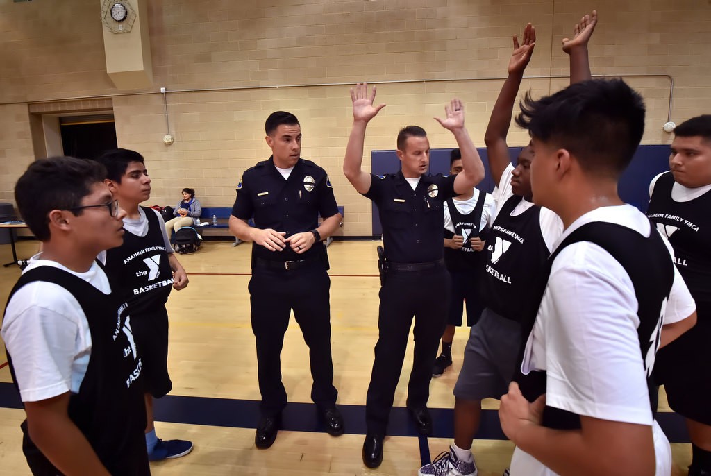 Anaheim PD officers Frank Ramirez, left, and Mark Gell coach their players between quarters during a basketball game at the West Anaheim Youth Center. Photo by Steven Georges/Behind the Badge OC