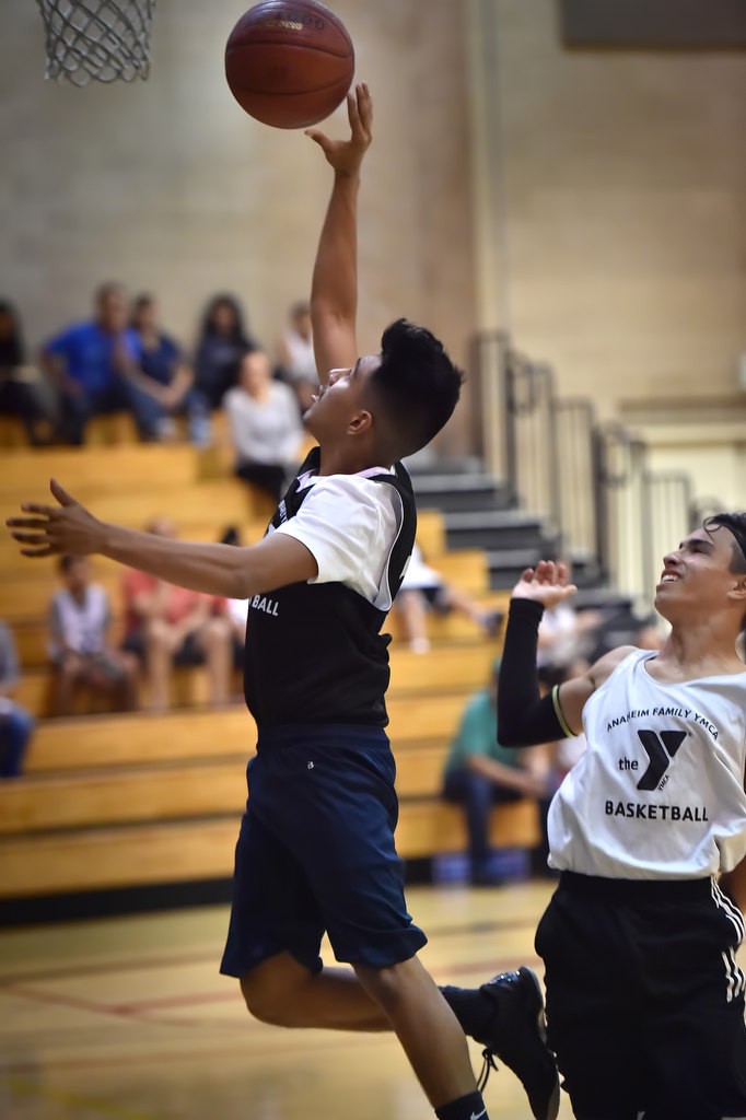 Brandon Delgado scores at the basket during a game at the West Anaheim Youth Center. Photo by Steven Georges/Behind the Badge OC