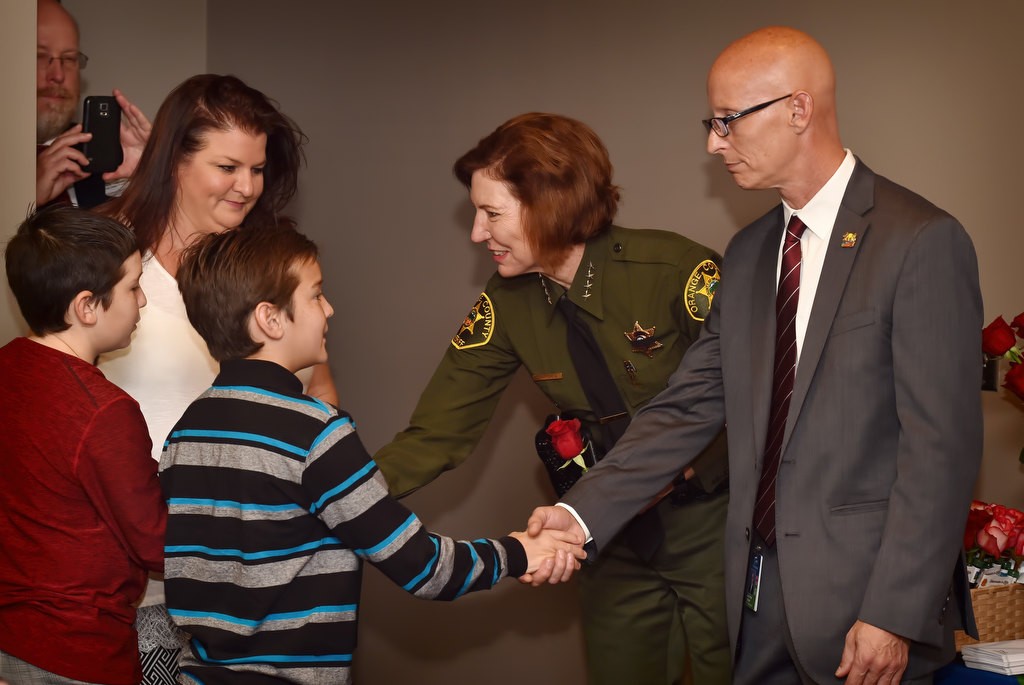 Orange County Sheriff Sandra Hutchens and Matthew Crump, vice president, tissue operations of OneLegacy, right, thanks the family members of an organ donor during a Donate Life America Rose Dedication ceremony at the OCSD’s Brad Gates Building in Santa Ana. Photo by Steven Georges/Behind the Badge OC