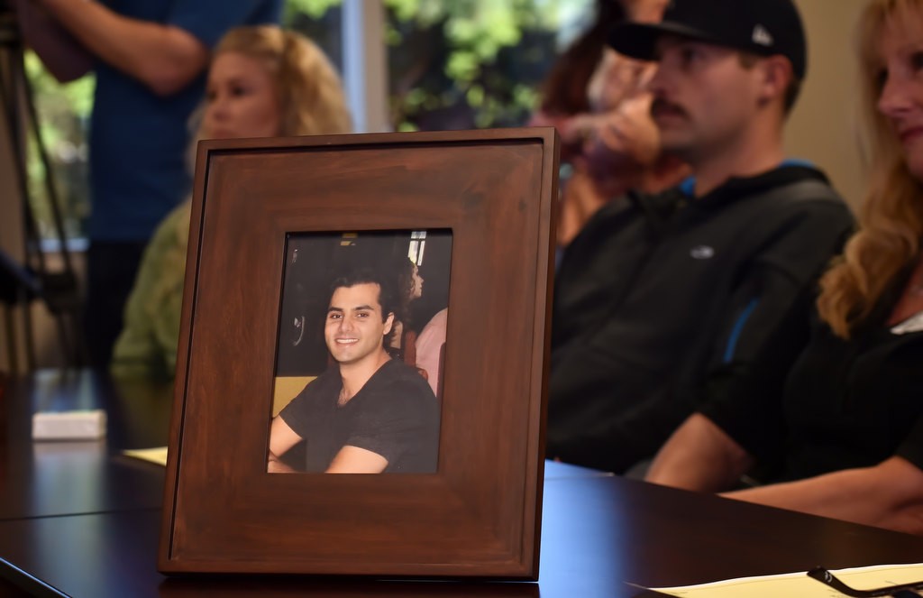 A photo of Nathan Bayati, who was 28 when his died and his organs were donated, sits on the table in front of his parents Christelle Bayati and Adnan Bayati (not in photo) as family members are honored during a Donate Life America Rose Dedication ceremony. Photo by Steven Georges/Behind the Badge OC