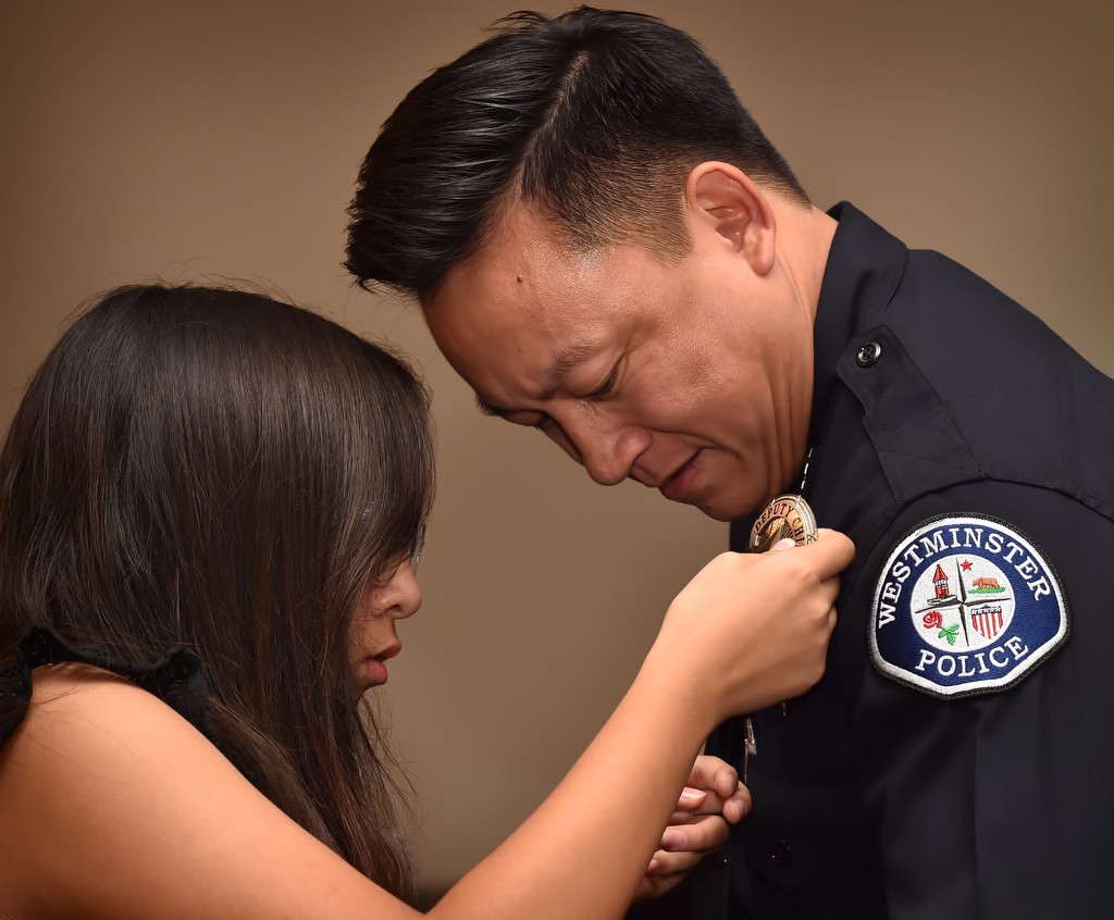 Timothy Vu receives his new Deputy Chief badge from his daughter, Tyler Vu, during a promotions Ceremony. Photo by Steven Georges/Behind the Badge OC