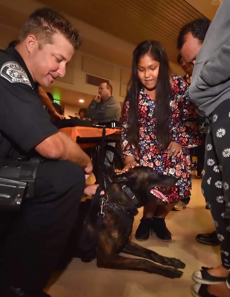 Nine-year-old Ariana Marin of Tustin gets her chance to pet Riggs, a Tustin police dog under the supervision of his handler Tustin PD Officer Eric Kent during Tustin PD’s fall Neighborhood Watch Block Captain Network Meeting at the Tustin Community Center. Photo by Steven Georges/Behind the Badge OC