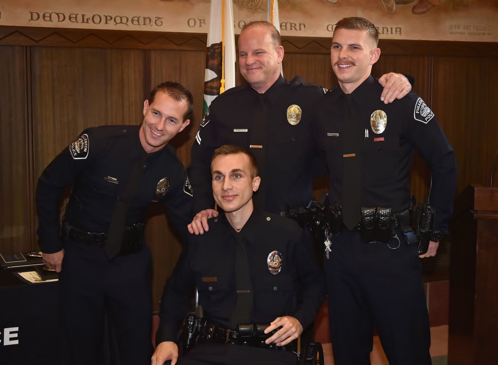 Los Angeles PD Officer Nick Wiltz, center in wheelchair, is greeted by Fullerton PD Officer Timothy Gibert, Cpl. Matt Wilkerson and Officer Michael Halverson, right, after a motorcycle accident back in August where the three helped save the life of Officer Wiltz. Photo by Steven Georges/Behind the Badge OC