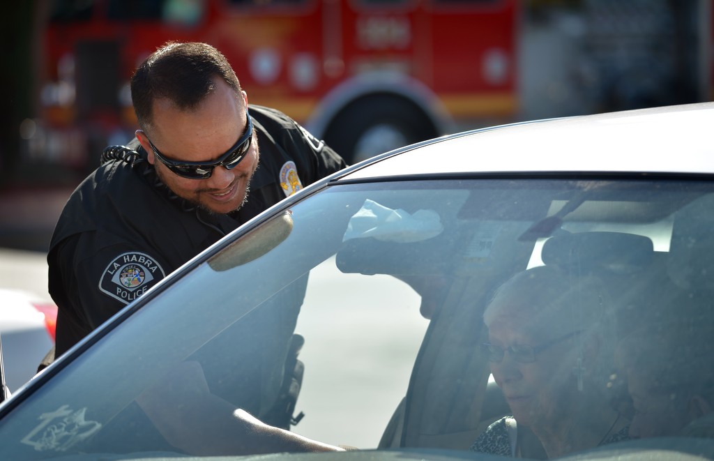 La Habra PD Officer Sumner Bohee talks to a woman as he checks handicap parking credentials at Sam’s Club in La Habra. Photo by Steven Georges/Behind the Badge OC