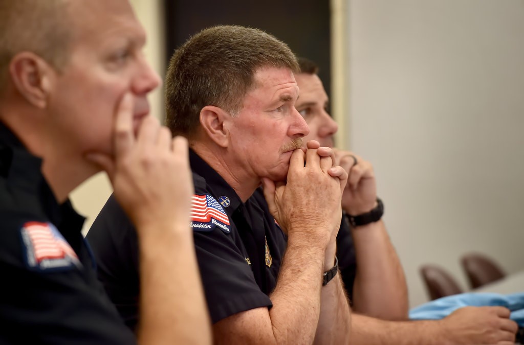 Allen Hogue, deputy fire marshal for Anaheim Fire & Rescue, center, listens, along with other firefighters, as UC Irvine Health talks about mens health issues during a education talk at the North Net Training Center in Anaheim. Photo by Steven Georges/Behind the Badge OC