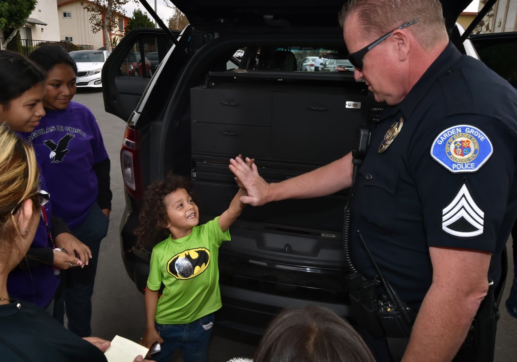 Kennith Cruc, 5, gives Garden Grove PD Sgt. Jon Wainwright a high-five and a big smile after Wainwright stored a scary clown mask in a police drawer. Kennith’s mother asked the sergeant to show him that the mask he was very afraid of was gone for good! Photo by Steven Georges/Behind the Badge OC