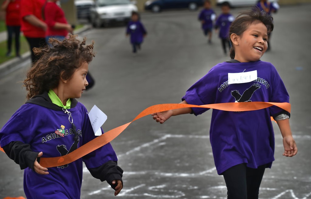 Kennith Cruc, 5, left, and Lindsey, 10, cross the finish line for one of the fun runs during a community gathering at the Palma Vista Ave. neighborhood in Garden Grove. Photo by Steven Georges/Behind the Badge OC