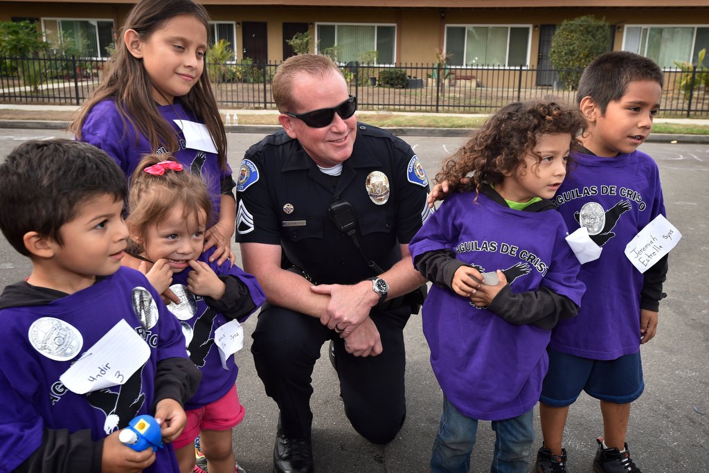 Garden Grove PD Sgt. Jon Wainwright gathers with some kids for a photo during a community gathering at the Palma Vista Ave. neighborhood in Garden Grove. Photo by Steven Georges/Behind the Badge OC