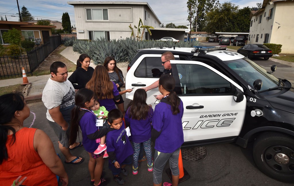 Garden Grove PD Sgt. Jon Wainwright gives kids from the the Palma Vista Ave. neighborhood a tour of a police sergeant’s SUV. Photo by Steven Georges/Behind the Badge OC