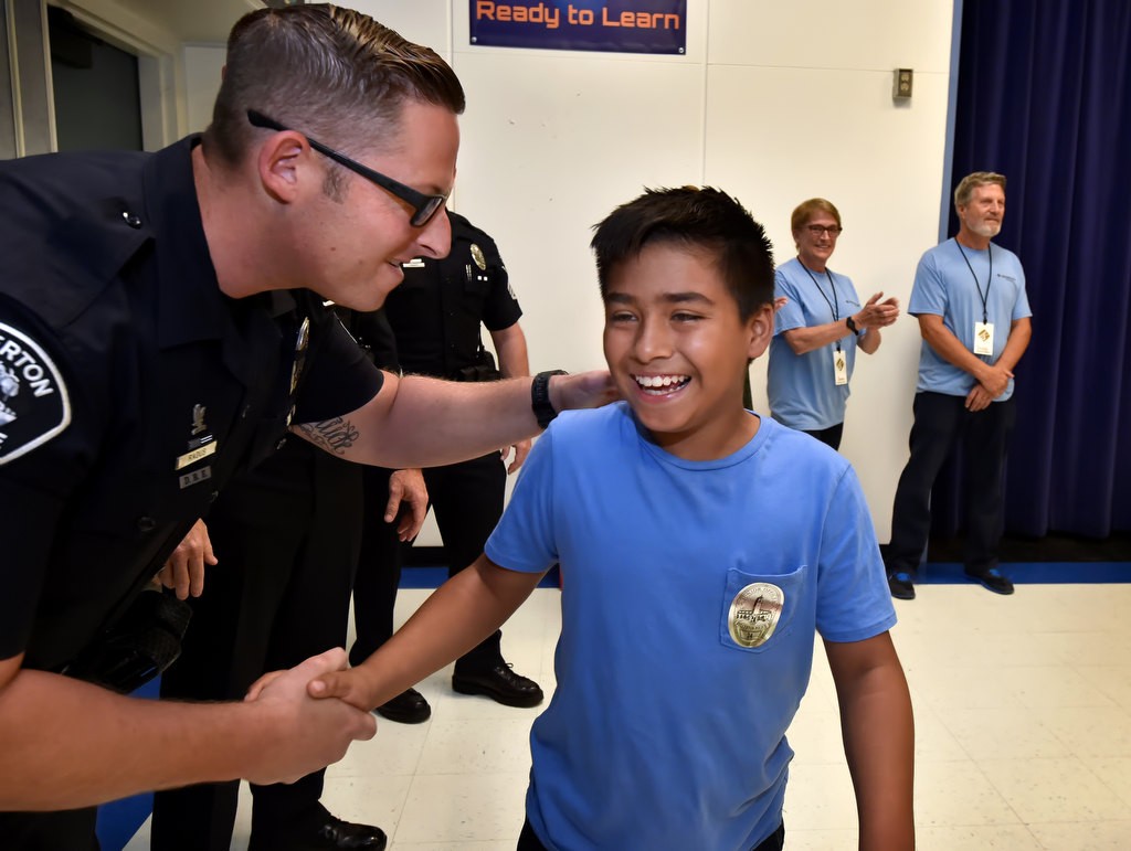Jesus Cordova, 10, gives a big smile as Fullerton PD Sgt. Jon Radus congratulates him for being honored by GRIP and earning a Turkey dinner for his family. Photo by Steven Georges/Behind the Badge OC