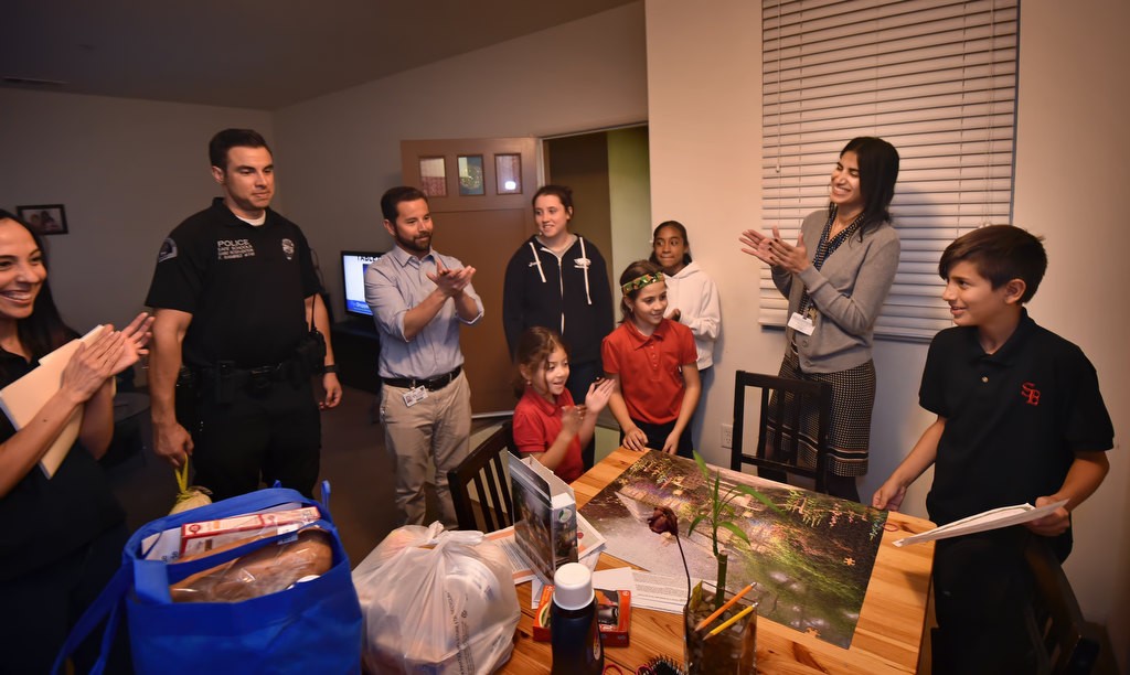 John Deniz Escobosa, 12, is honored with a turkey dinner brought to his home by a team that includes Anaheim PD Officer Frank Ramirez, Sycamore Jr. High Assistant Principal David Okamoto and Judeh Fatinah of Sycamore Jr. High. Photo by Steven Georges/Behind the Badge OC