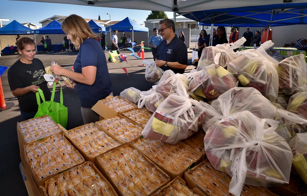 Allison Mills, division manager for Garden Grove, hands out pasta and organic chips to local residents during a Palma Vista/El Dorado Community Outreach Event. Photo by Steven Georges/Behind the Badge OC
