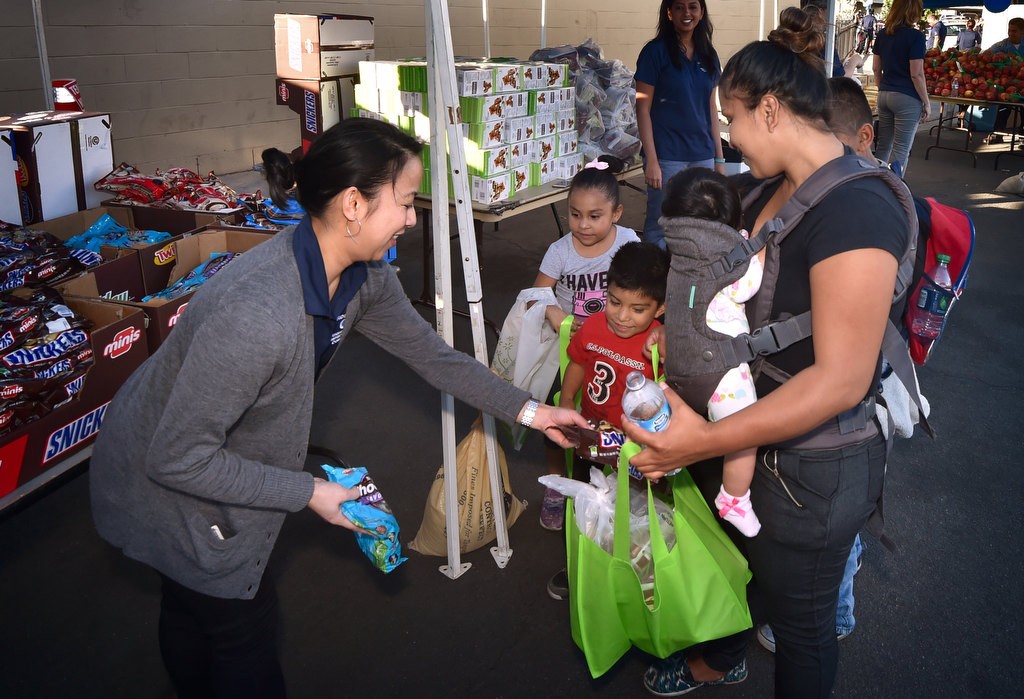 Ann Eifert, of the Garden Grove Neighborhood Improvement Committee, left, hands out treats for the kids during a Palma Vista/El Dorado Community Outreach Event. Photo by Steven Georges/Behind the Badge OC