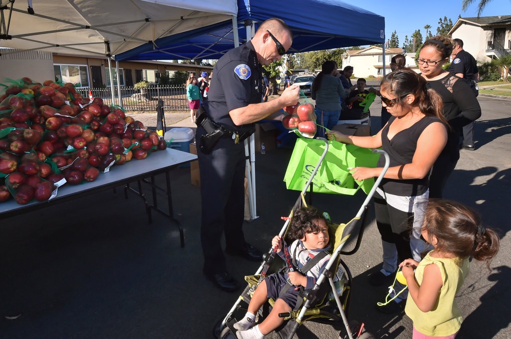Garden Grove Police Chief Todd Elgin hands out apples to local families during a Palma Vista/El Dorado Community Outreach Event. Photo by Steven Georges/Behind the Badge OC