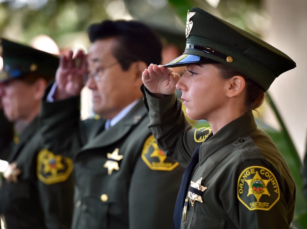 OC Sheriff Deputy Antoinette Bustamante, right, salutes with her fellow deputies as Deputy Courtney WardÕs casket leaves the church. Photo by Steven Georges/Behind the Badge OC