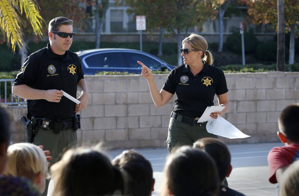 Deputy Todd Skoczulek, and Crime Prevention Specialist  Kimberly Sawyer give bicycle safety advise to elementary school students in Laguna Niguel. Photo by Christine Cotter