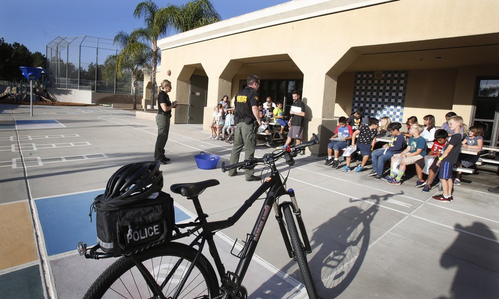 Deputy Todd Skoczulek, and Crime Prevention Specialist  Kimberly Sawyer give bicycle safety tips to Laguna Niguel elementary students. Photo by Christine Cotter