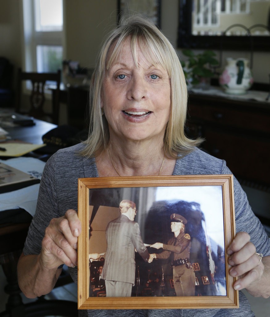 Elizabeth Dove holding a photo of herself and Sheriff Brad Gates from her 1982 graduation. Photo by Christine Cotter