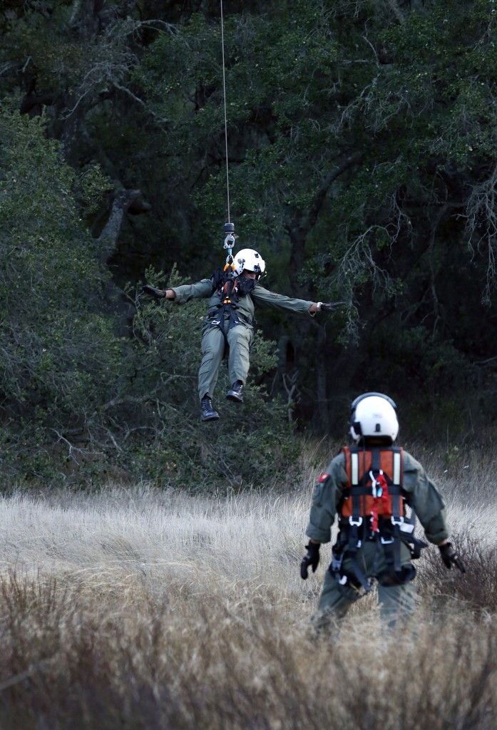 Jim Slikker, top, is lowered to the ground by the Orange County Sheriff's Search and Rescue helicopter during a recent training exercise. Photo by Christine Cotter