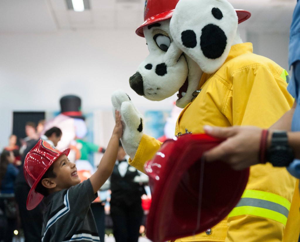 Ronnie Zapeda, 5, high-fives Anaheim Fire mascot Captain d. Tector at Monday's annual party for burn survivors at the Anaheim Convention Center put on by the UC Irvine Health Regional Burn Center.