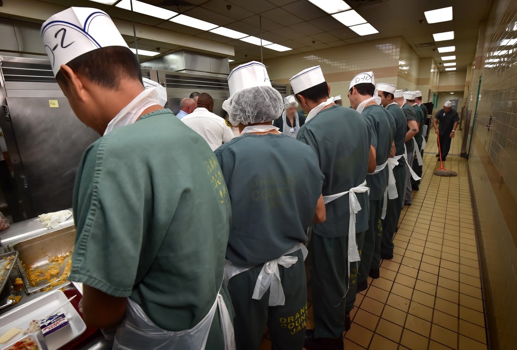 Inmates line up to help dish out food on each plate at the Theo Lacy Facility for an upcoming meal. Photo by Steven Georges/Behind the Badge OC