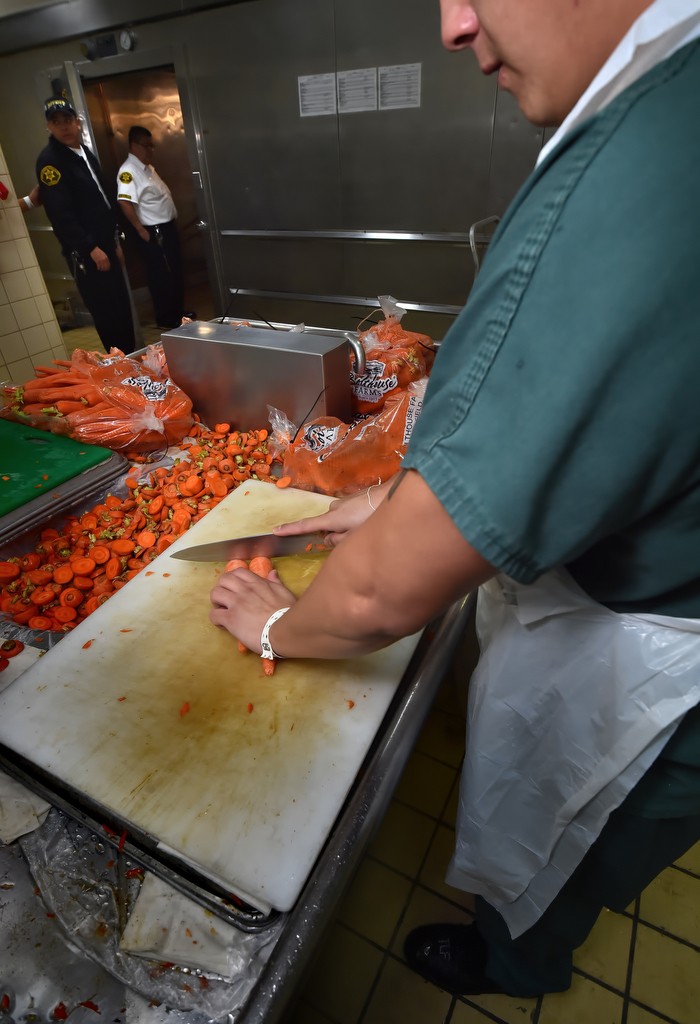 Inmates help prepare the food at the Theo Lacy Facility each day. In the background are walk-in freezers and refrigerators. Photo by Steven Georges/Behind the Badge OC