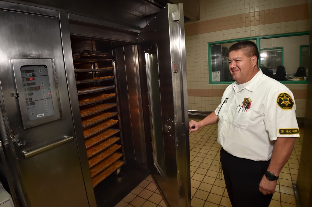 Marcelo Jimenez, senior head cook at Theo Lacy Facility in Orange, opens a door for an oven used to help feed the well over 3,000 inmates at the jail. Photo by Steven Georges/Behind the Badge OC