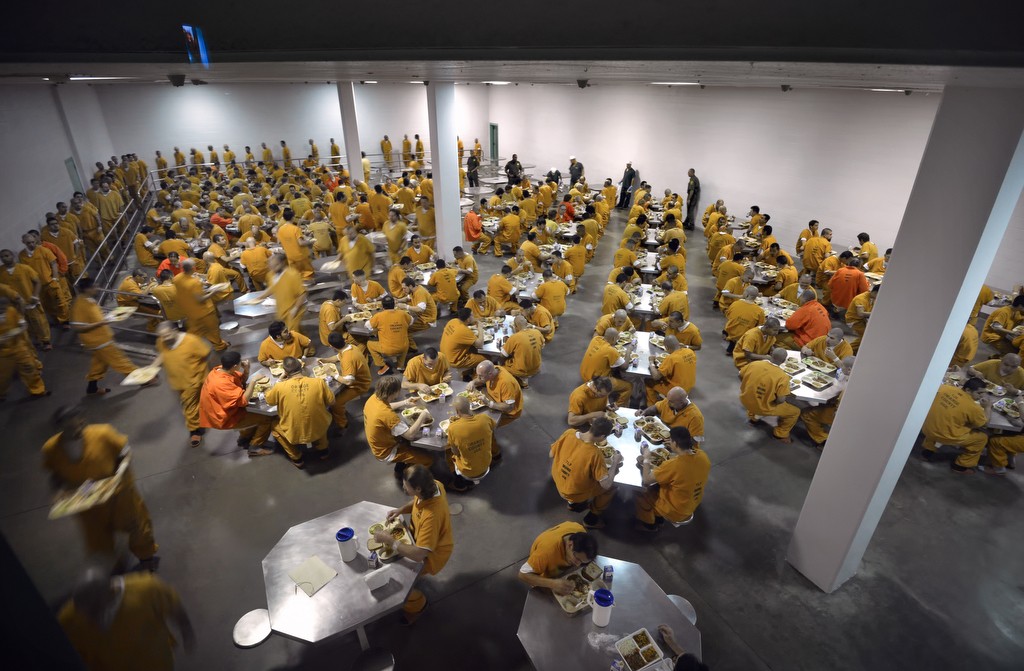 In this 2012 file photo, inmates line up to get their food and sit down at the start of dinner in a dining room capable of feeding 292 inmates at the Theo Lacy Facility jail in the City of Orange. Photo by Steven Georges 