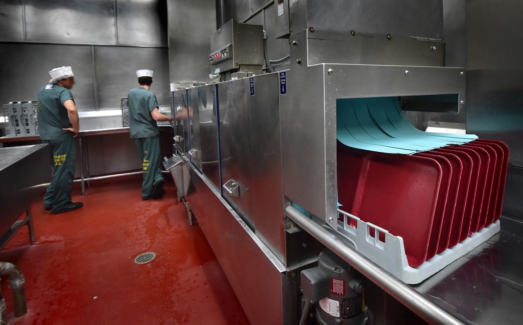 Industrial dishwashers, with the help of inmate workers, are used to clean the large volume of plates, cups and trays served at the Theo Lacy Facility each day. Photo by Steven Georges/Behind the Badge OC