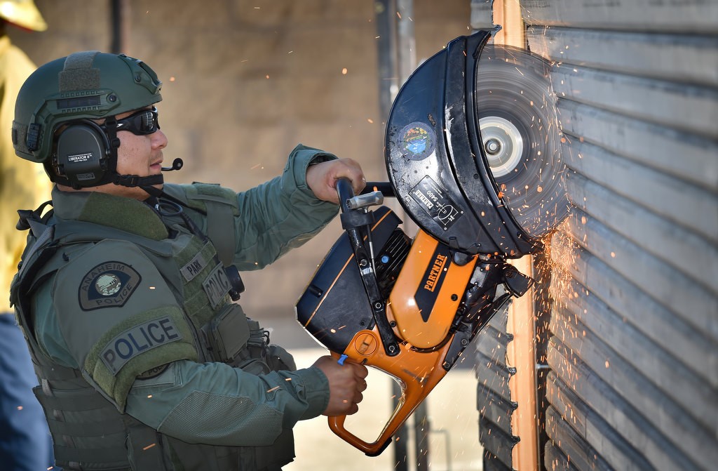 Anaheim SWAT officer xxx Park uses a circular saw to cut through medial gates during a training exercise at the North Net Training Center. Photo by Steven Georges/Behind the Badge OC