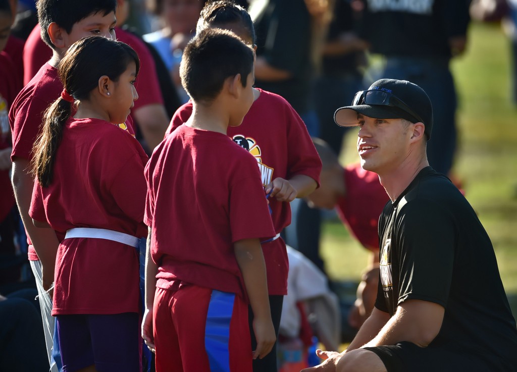 Tustin PD Officer Joe Cossack talks to hit team as he helps coach kids during a flag football tournament at Heideman Elementary. Photo by Steven Georges/Behind the Badge OC