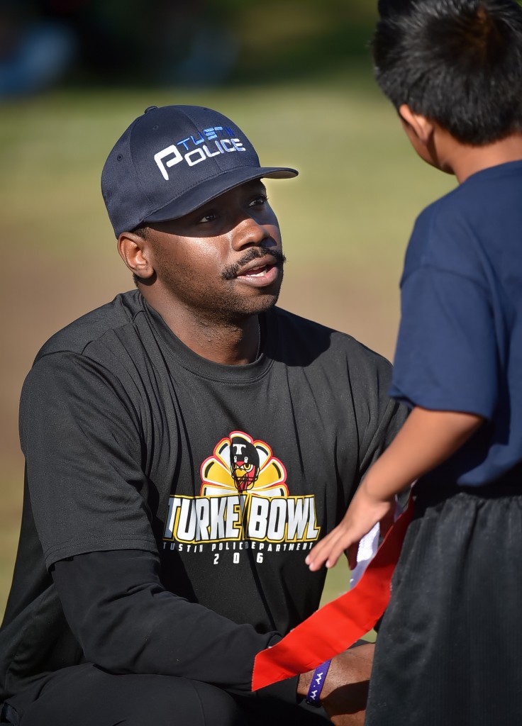 Tustin Police Officer Robert Nelson gives some words of encouragement to a student during a break in a flag football game. Photo by Steven Georges/Behind the Badge OC