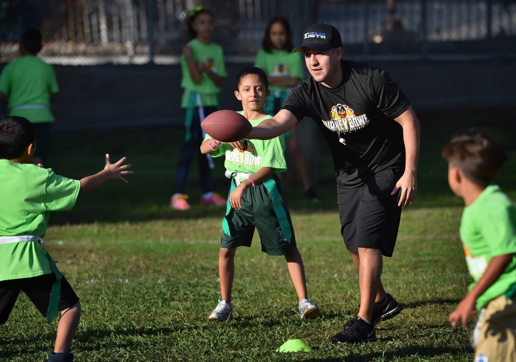 Tustin PD Sgt. Manny Arzate coaches kids from Heideman Elementary during a flag football tournament. Photo by Steven Georges/Behind the Badge OC