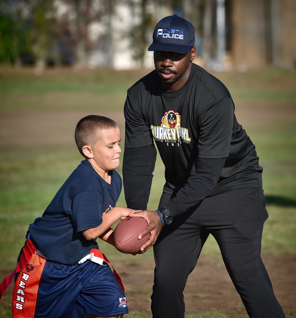 Tustin Police Officer Robert Nelson works with his team at the start of a flag football tournament at Heideman Elementary. Photo by Steven Georges/Behind the Badge OC