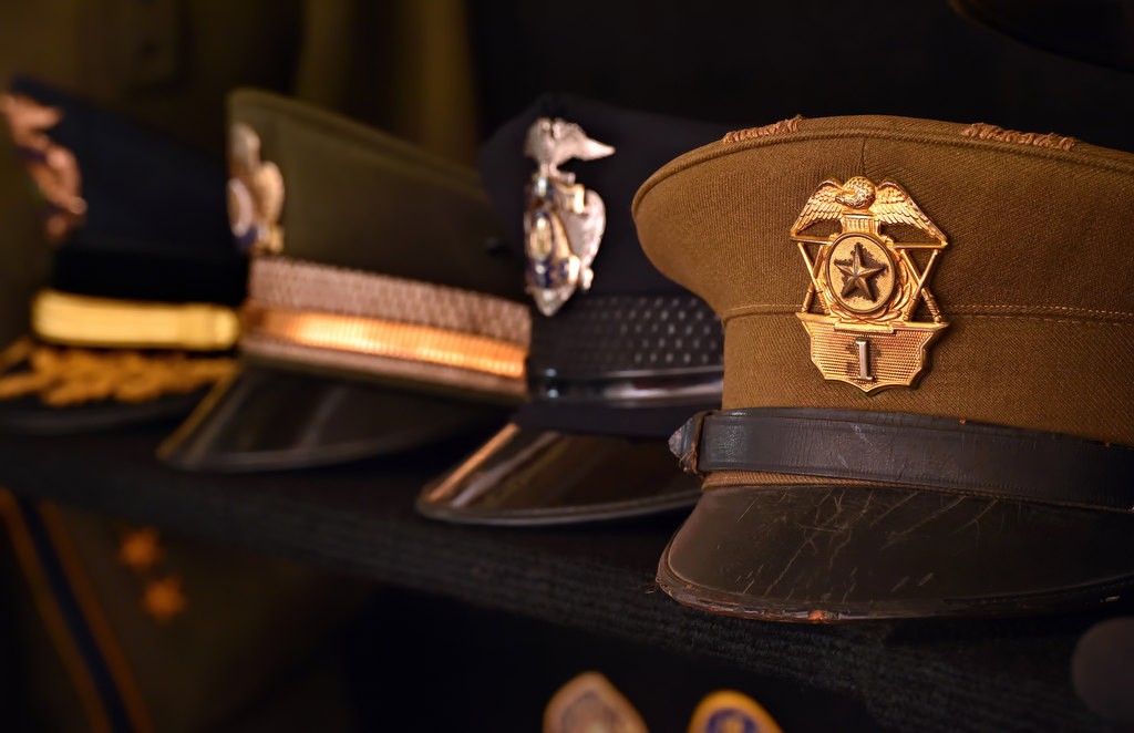 A collection of police hats from years gone by including a Standard Fullerton Police hat, right, from the 1920-30’s. Photo by Steven Georges/Behind the Badge OC