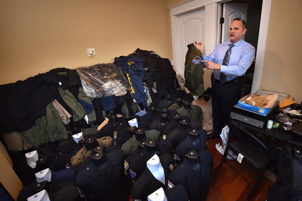 Stan Berry, supervising investigator for the Orange County District Attorney’s office, shows his extensive police uniform collection from all over Orange County including an older style uniform from Huntington Beach PD. Photo by Steven Georges/Behind the Badge OC