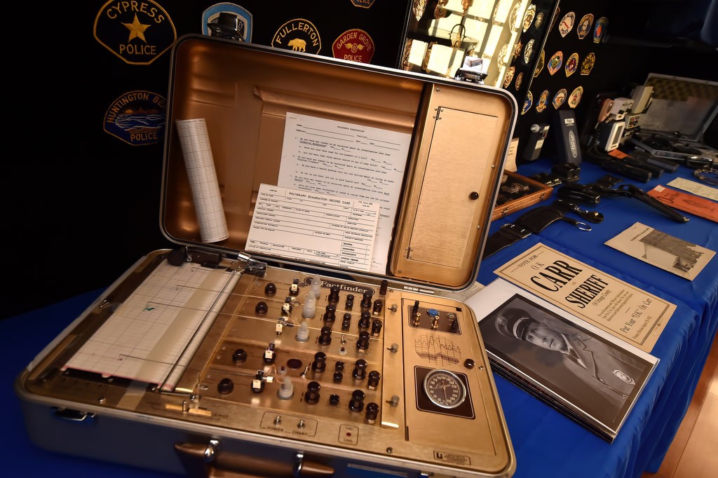 A polygraph machine with a brand name of The Factfinder that was last used by the district attorneys office in the 1980’s. Polygraph machines are no longer used by the office for criminal investigations. To the right is a photograph of Fullerton Police Chief James M. Pearson who served as chief from 1927-1940, and a 1922 Carr for OC Sheriff campaign flyer. Photo by Steven Georges/Behind the Badge OC