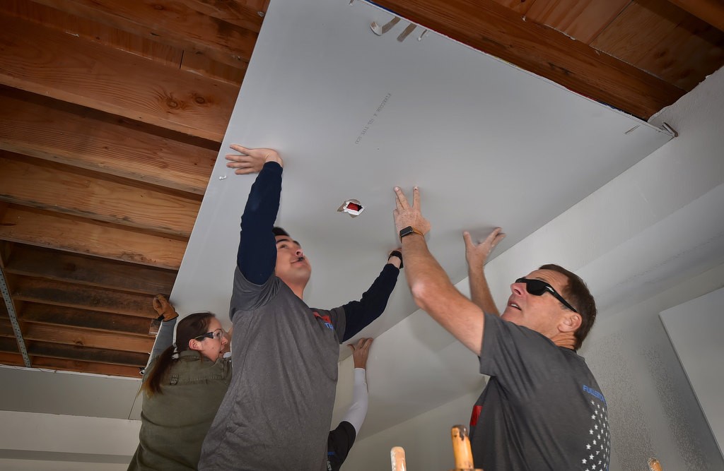 Fullerton PD Officers help place a celling cover to a Habitat For Humanity home for veterans. Photo by Steven Georges/Behind the Badge OC