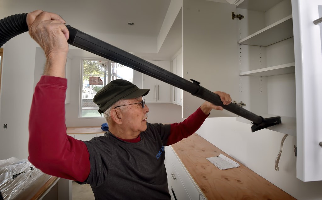 Aki Tanaka, a volunteer with Fullerton PD since 2007, vacuums the kitchen area as he helps out with a Habitat For Humanity home project. Photo by Steven Georges/Behind the Badge OC