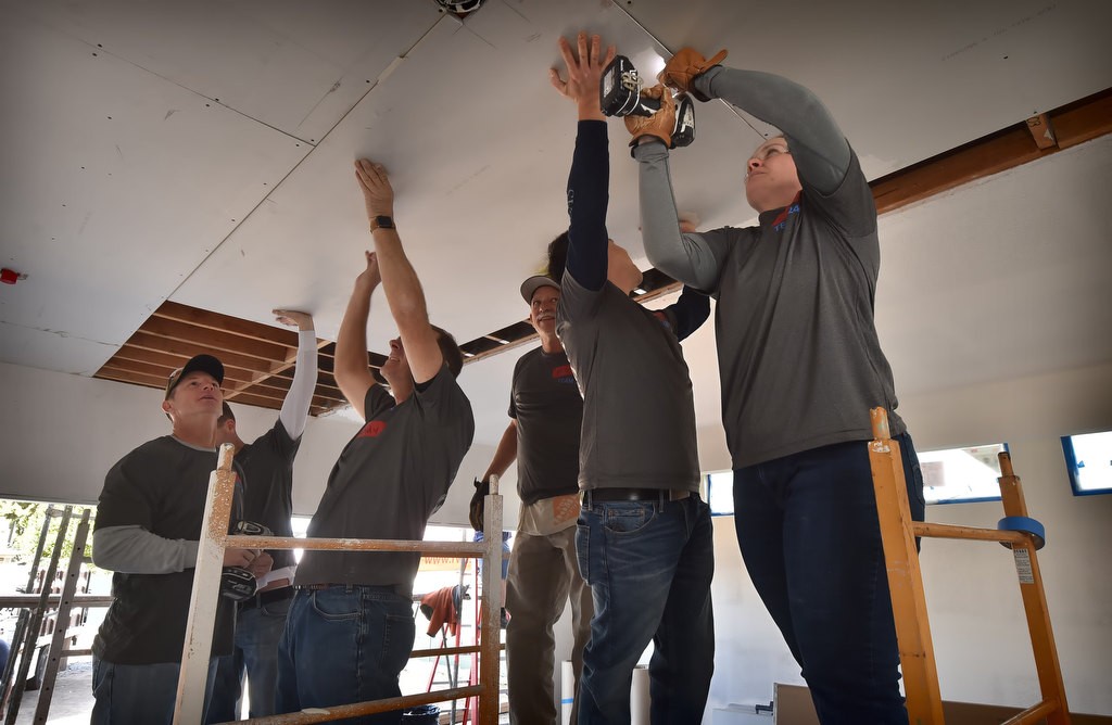 Volunteers with the Fullerton PD help install a celling cover for a Habitat For Humanity home project. Photo by Steven Georges/Behind the Badge OC