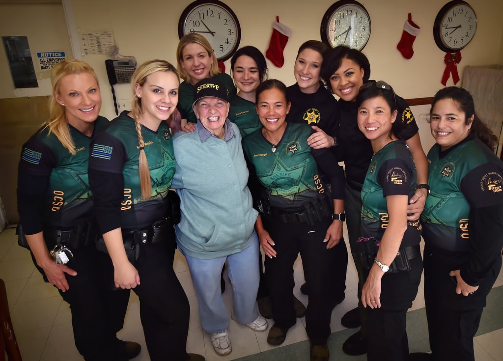 Alice Chandler wears an Orange County Sheriff hat given to her by the OCSD Ladies Trigger Team during a visit. The team from left is Dana Chaney, Norelly MejiaZea, Carla Dane, (Alice Chandler), Maria Bowman, Jean Tindugan, Dallas Mihalik, Olivia Coco, Susan Huang and Gina Garduno. Photo by Steven Georges/Behind the Badge OC